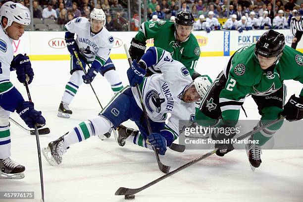 Alex Chiasson of the Dallas Stars skates the puck away from Brad Richardson of the Vancouver Canucks in the first period at American Airlines Center...