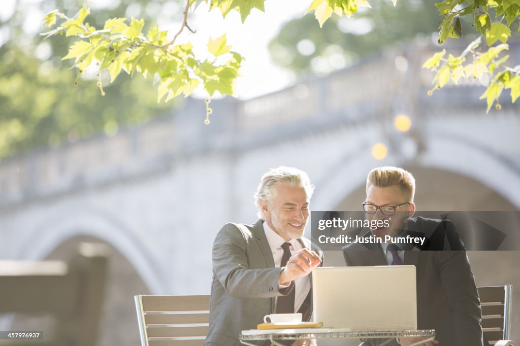 Businessmen working at sidewalk cafe