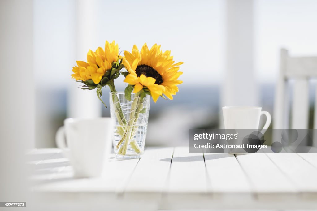 Vase of flowers and coffee cups on kitchen table