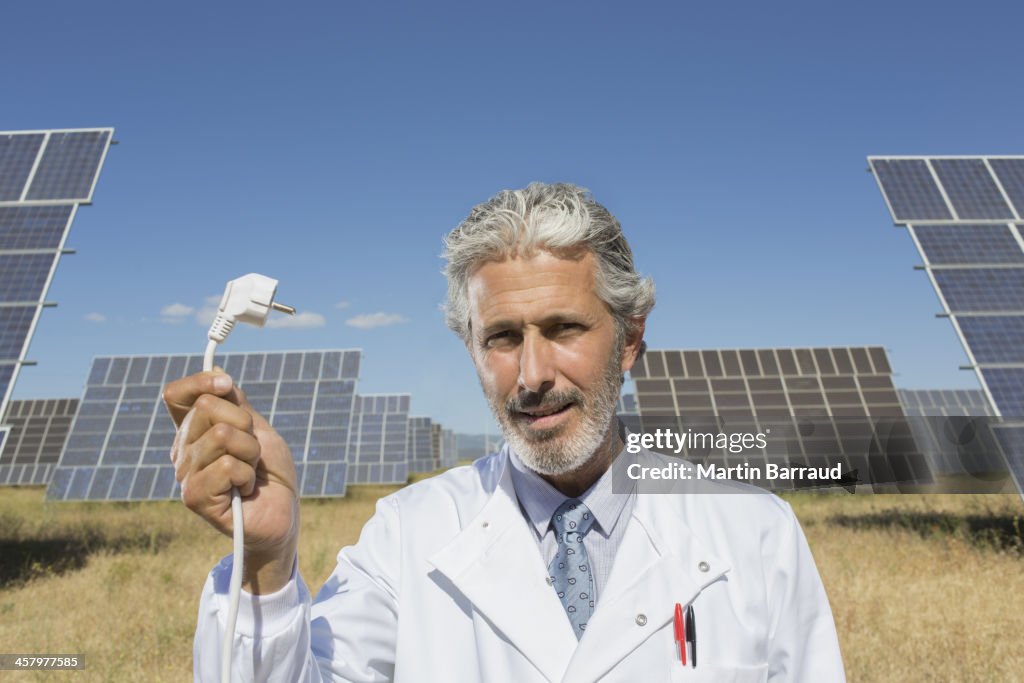 Scientist holding plug to solar panels