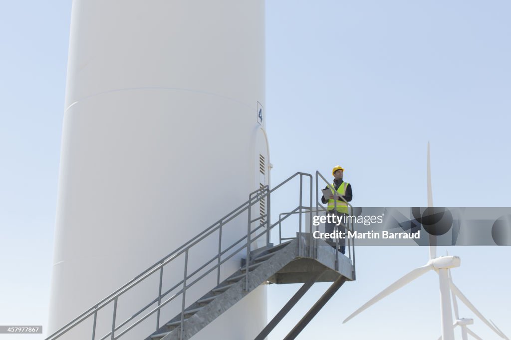 Worker standing on wind turbine