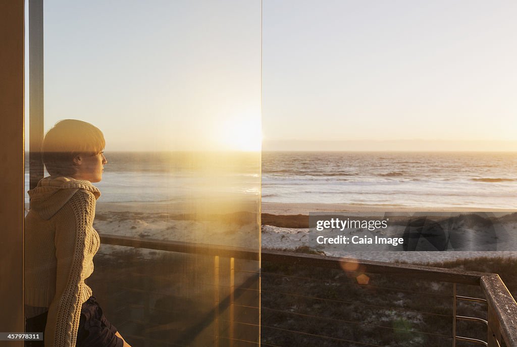 女性は海に沈む夕日を眺め