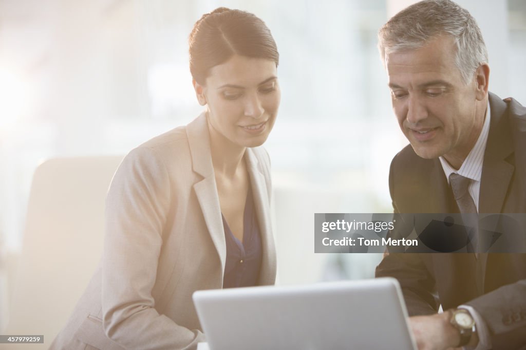 Business people using laptop in office