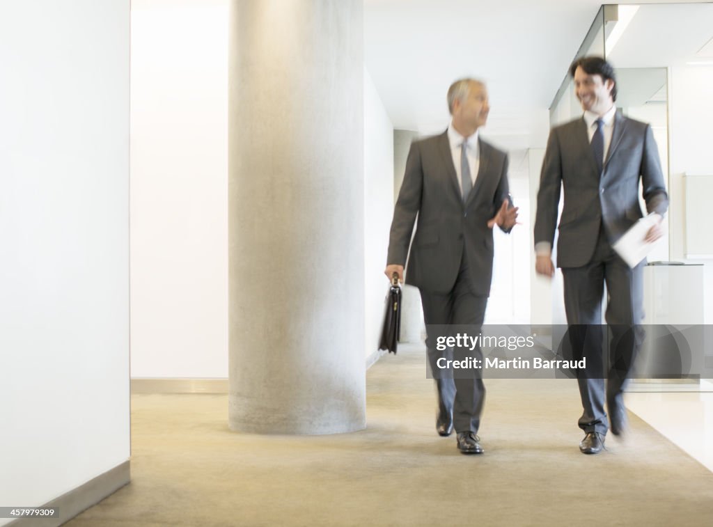 Businessmen talking in office corridor