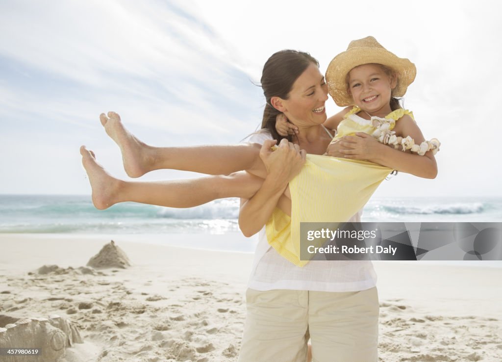 Mother holding daughter on beach