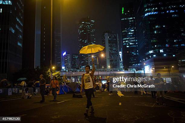 Pro-democracy activists walks with a yellow umbrella on a street outside Hong Kong's Government Complexon October 28, 2014 in Hong Kong, Hong Kong....