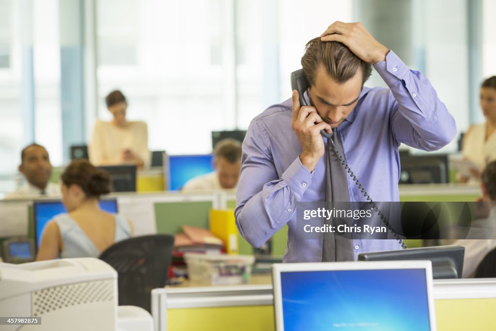 Businessman talking on telephone in office