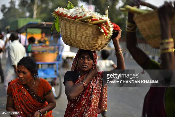 An Indian Hindu devotee carries items used during religious ceremonies a day ahead of the Chhat festival in New Delhi on October 28, 2014. The Chhat...