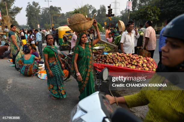 An Indian Hindu devotee carries items used during religious ceremonies a day ahead of the Chhat festival in New Delhi on October 28, 2014. The Chhat...