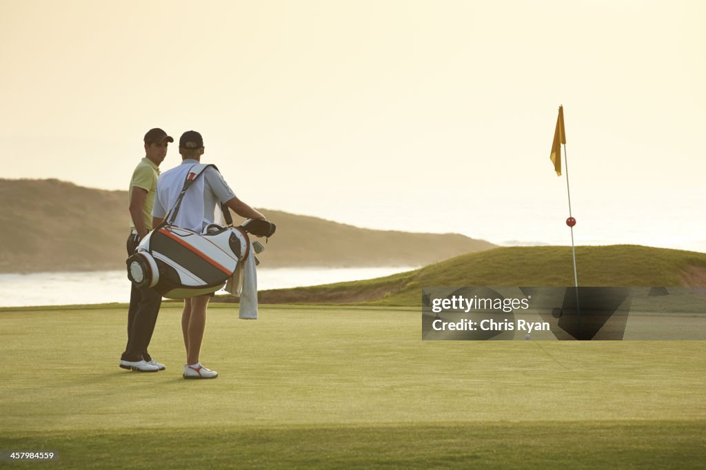 Men on golf course overlooking ocean