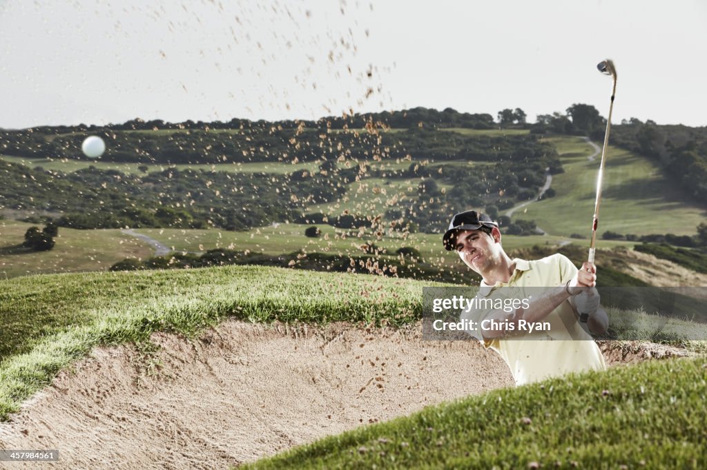 Mann schwingen von sand trap auf den Golfplatz