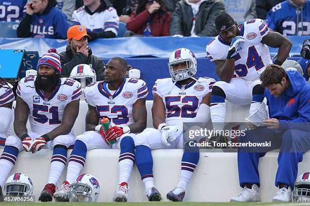 Brandon Spikes of the Buffalo Bills and Nigel Bradham and Preston Brown and Larry Dean look on from the bench during NFL game action against the...