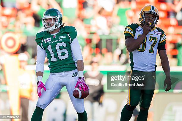 Brett Swain of the Saskatchewan Roughriders celebrates after a catch for a touchdown as Otha Foster of the Edmonton Eskimos looks on in a game...