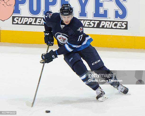 Adam Lowry of the Winnipeg Jets plays the puck during second period action against the Calgary Flames on October 19, 2014 at the MTS Centre in...