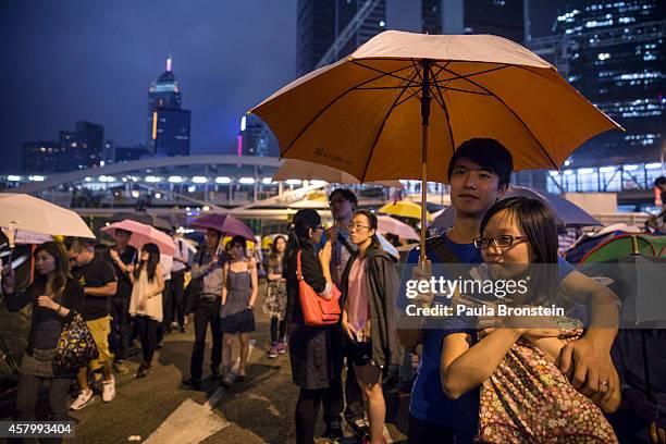 Umbrellas are opened as tens of thousands come to the main protest site one month after the Hong Kong police used tear gas to disperse protesters...