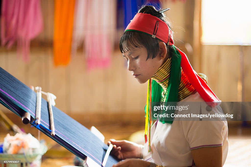 Mature woman in traditional clothing weaving, Inle lake, Burma