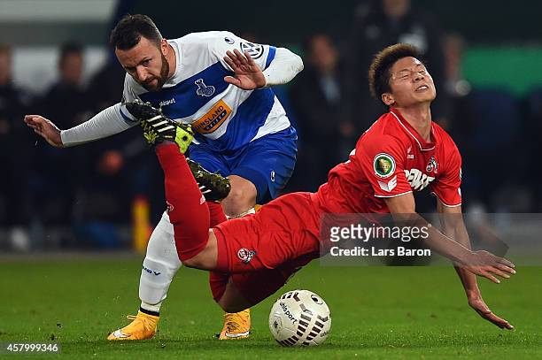 Zlatko Janjic of Duisburg challenges Kazuki Nagasawa of Koeln during the DFB Cup second round match between MSV Duisburg and 1. FC Koeln at...