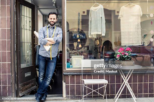 portrait of confident mid adult male designer standing at studio entrance - fashion designer stock pictures, royalty-free photos & images