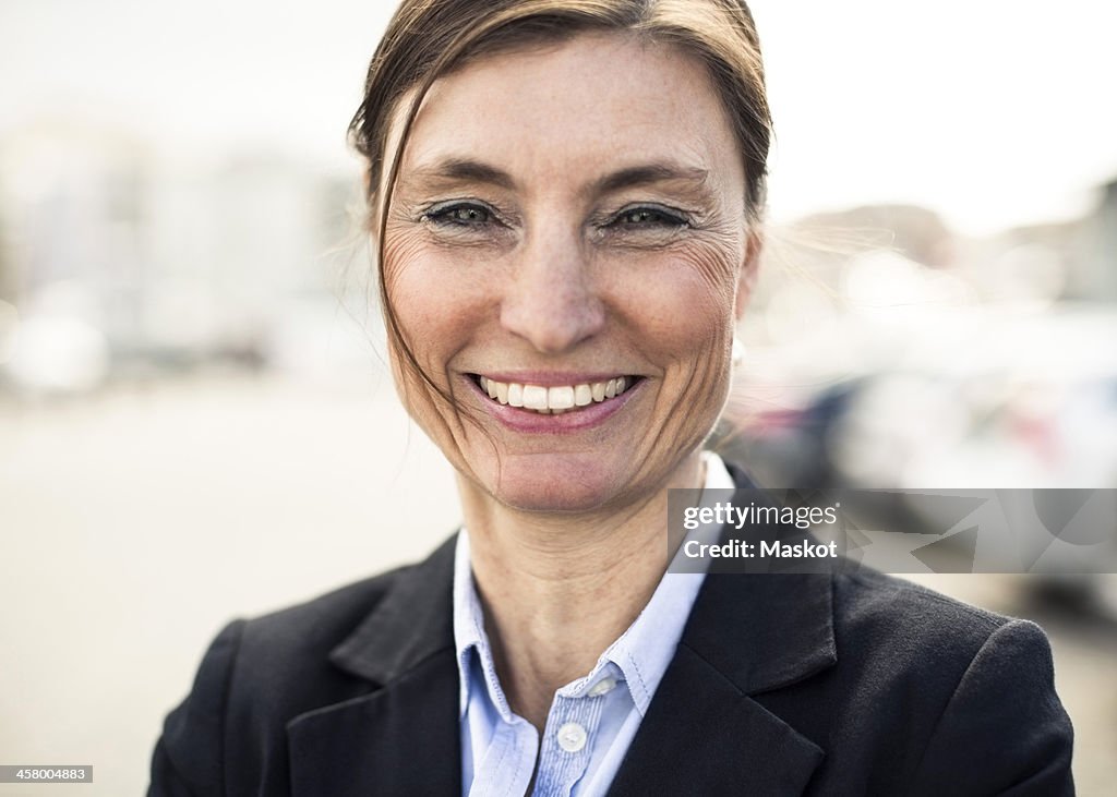 Portrait of happy mature businesswoman smiling outdoors