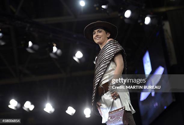 French TV host Sophie Jovillard presents a chocolate dress during the Paris Chocolate fair , on October 28, 2014 in Paris. AFP PHOTO / MARTIN BUREAU