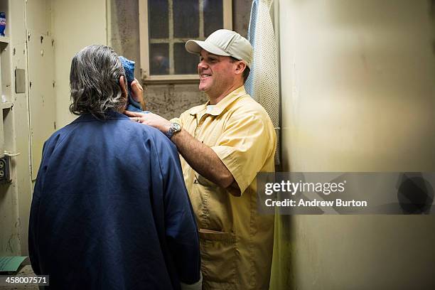 David Barnhill, a member of the Gold Coats program, helps an elderly prisoner at California Men's Colony prison on December 19, 2013 in San Luis...