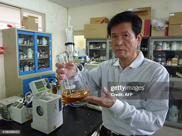 This picture taken on November 12, 2013 shows Shinkichi Tawada, professor of the faculty of Agriculture at the University of the Ryukyus displays an...
