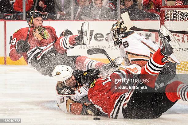 Bryan Bickell and Jonathan Toews Chicago Blackhawks collide with Hampus Lindholm of the Anaheim Ducks into goalie John Gibson during the NHL game on...