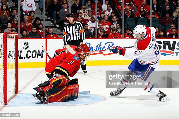 Jonas Hiller of the Calgary Flames makes a save against Alex Galchenyuk of the Montreal Canadiens at Scotiabank Saddledome on October 28, 2014 in...