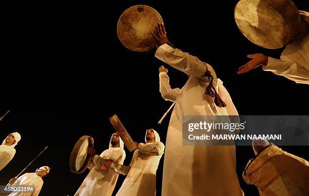 Emirati men play instruments as they perform a traditional dance late on October 28, 2014 during a festival in the city of Al-Ain celebrating...