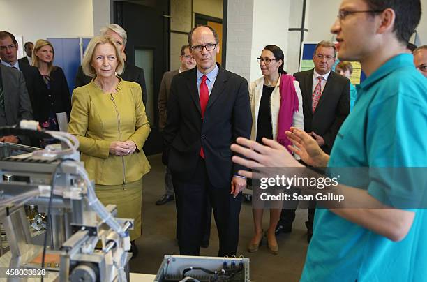 Labor Secretary Thomas Perez and German Education Minister Johanna Wanka listen to trainees explain their training program at the Siemens training...