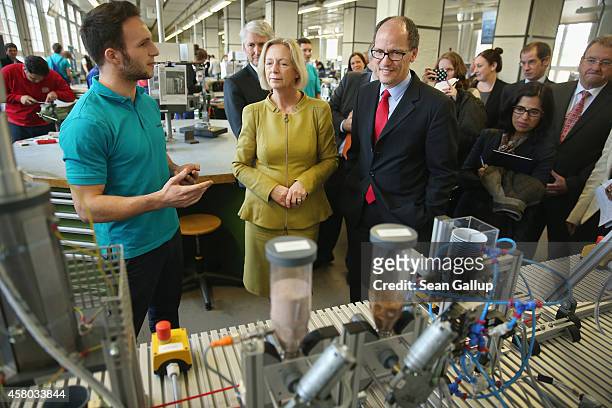 Labor Secretary Thomas Perez listens to trainee Tim Demol explain the functions of an automated coffee brewing machine created as a technical...