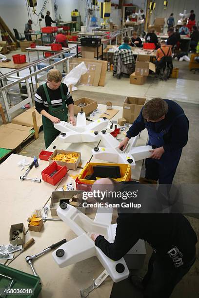 Workers assemble commemorative lamps at the workshops for the handicapped of the German Red Cross in Nuthetal on October 29, 2014 near Potsdam,...