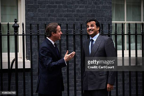 British Prime Minister David Cameron greets Sheikh Tamim bin Hamad Al Thani, the Emir of Qatar, at Downing Street on October 29, 2014 in London,...