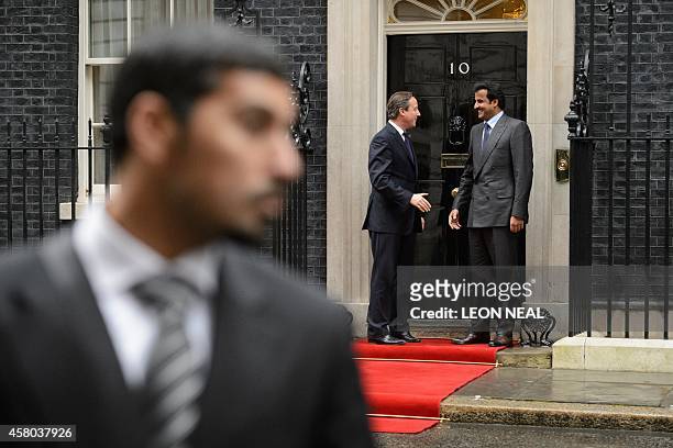 British Prime Minister David Cameron greets the Emir of Qatar Sheikh Tamim Bin Hamad Al Thani outside 10 Downing Street in London, on October 29,...
