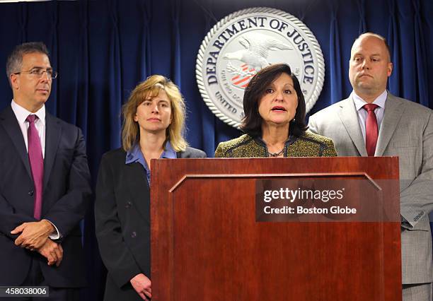 Attorney Carmen Ortiz addresses the media flanked by federal prosecutors John Capin, left, and Stephanie Seigman and Acting FBI Special Agent in...