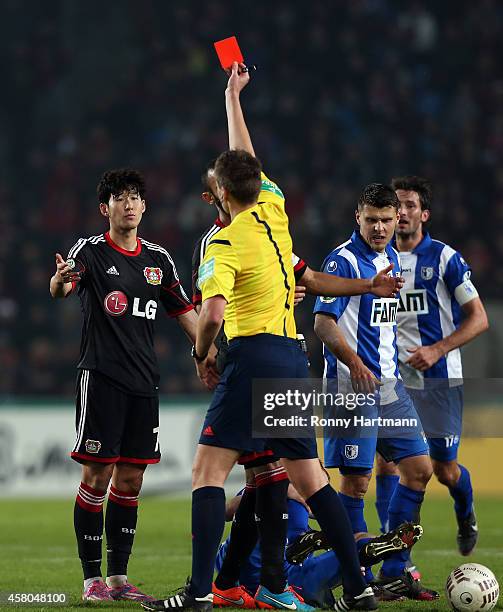 Referee Daniel Siebert shows the red card to Heung-Min Son of Leverkusen during the DFB Cup second round match between 1. FC Magdeburg and Werder...
