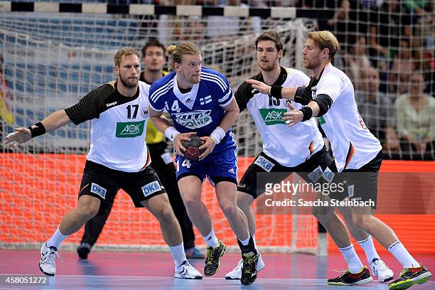 Steffen Weinhold, Hendrik Pekeler and Manuel Spaeth of Germany challenge Leonel Henrik Ojala of Finland during the 2016 European Men's Handball...