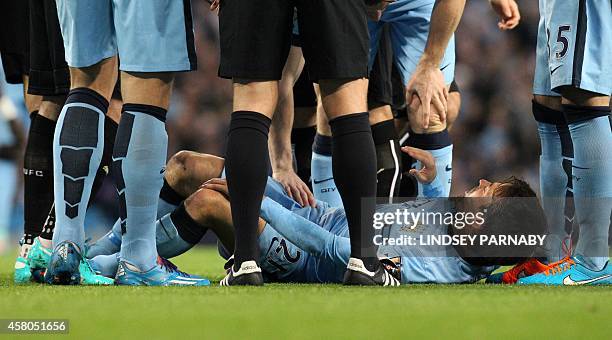 Manchester City's Spanish midfielder David Silva lies injured during the English League Cup fourth round football match between Manchester City and...