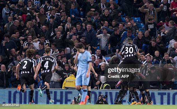 Teammates and fans celebrate Newcastle United's French midfielder Moussa Sissoko's goal during the English League Cup fourth round football match...