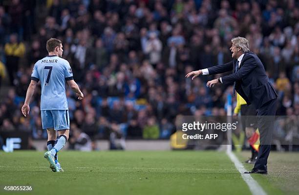 Manchester City's Chilean manager Manuel Pellegrini speaks with Manchester City's English midfielder James Milner from the touchline during the...
