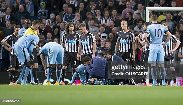 Manchester City's Spanish midfielder David Silva receives attention after a challenge by Newcastle United's English defender Ryan Taylor during the...