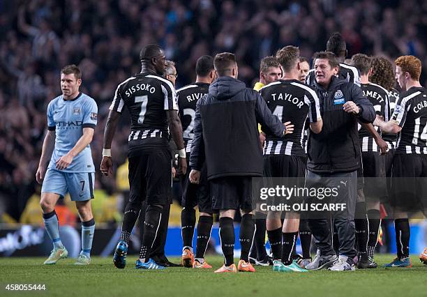 Manchester City's English midfielder James Milner walks from the pitch as Newcastle United's players celebrate winning during the English League Cup...