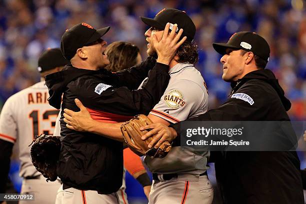 Tim Hudson celebrates with Madison Bumgarner of the San Francisco Giants on the field after defeating the Kansas City Royals 3-2 to win Game Seven of...