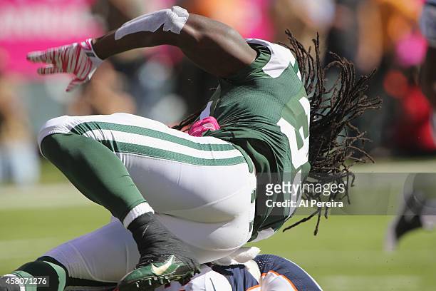 Running Back Chris Ivory of the New York Jets has his dreads fly when he is stopped by Linebacker Corey Nelson of the Denver Broncos at MetLife...