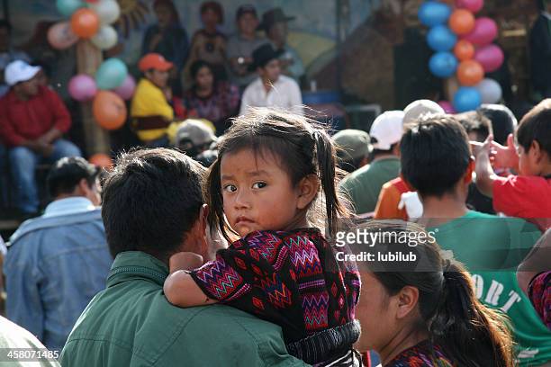 little curious mayan girl with her parents in chichicastenango, guatemala - central america stock pictures, royalty-free photos & images