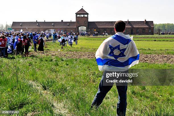 o participante vestindo uma bandeira israelense de auschwitz -birkenau morte camp - dia-da-memória-do-holocausto - fotografias e filmes do acervo
