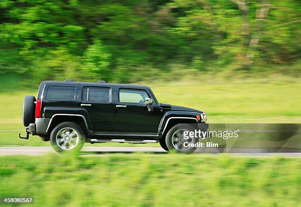 hummer h3 driving on country road in spring - hummer h3 stock pictures, royalty-free photos & images
