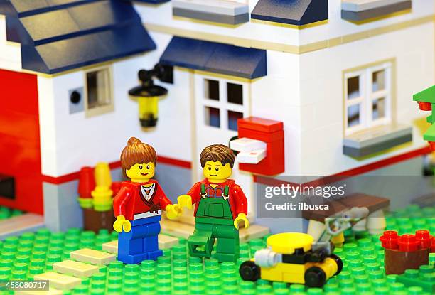 happy lego paar mit neuen haus - building lego stock-fotos und bilder