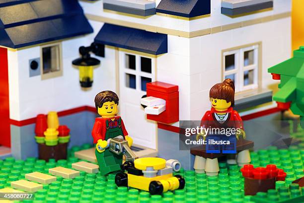 happy lego paar mit neuen haus - building lego stock-fotos und bilder