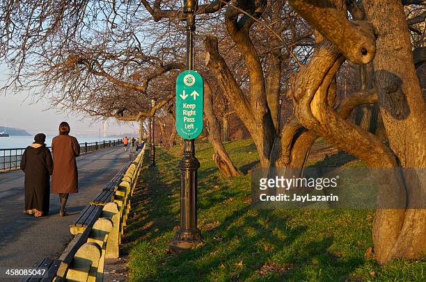 people on riverside park promenade at sunset, new york city - riverside park manhattan stock pictures, royalty-free photos & images
